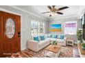 Bright living room features a large sectional couch, wood-look flooring, and natural lighting at 5324 3Rd N Ave, St Petersburg, FL 33710