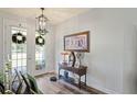 Inviting entryway featuring hardwood floors, stylish lighting, and a charming side table at 5458 Zamia Dr, Brooksville, FL 34604