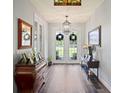Inviting entryway featuring hardwood floors, stylish lighting, and charming decor at 5458 Zamia Dr, Brooksville, FL 34604