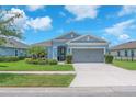 Charming single-story home featuring a well-manicured lawn, lush landscaping, and a two-car garage at 5539 Silver Sun Dr, Apollo Beach, FL 33572