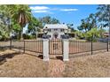 Captivating two-story home with manicured lawn, decorative metal gate, and brick walkway at 5603 Palmetto Rd, New Port Richey, FL 34652