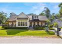 Charming home with a metal roof, a welcoming covered porch, and well-manicured landscaping at 5610 N River Shore Dr, Tampa, FL 33603