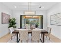 Bright dining room with modern chandelier and views to the backyard through sliding glass doors at 5865 Creek Ridge Rd, Brooksville, FL 34601