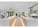 Bright kitchen featuring a double island, modern appliances, light wood floors and pendant lighting at 5865 Creek Ridge Rd, Brooksville, FL 34601
