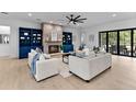 Open-concept living room with a stone fireplace, built-in shelves, and sliding doors to the exterior at 5865 Creek Ridge Rd, Brooksville, FL 34601