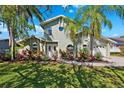 Charming two-story home with lush tropical landscaping, a circular window and an attached two car garage at 640 Kenneth Way, Tarpon Springs, FL 34689