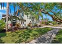 Charming home featuring lush landscaping, a sidewalk, and a well-maintained lawn at 640 Kenneth Way, Tarpon Springs, FL 34689