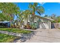 Charming home with lush landscaping, mature trees and a well-manicured lawn at 640 Kenneth Way, Tarpon Springs, FL 34689