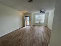 Spacious living room with wood-look tile flooring, a ceiling fan, and bright natural light at 6405 Osprey Lake Cir, Riverview, FL 33578