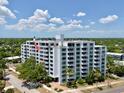 Exterior view of the condo building featuring balconies, lush landscaping, and a well-maintained facade at 700 Beach Ne Dr # 705, St Petersburg, FL 33701