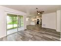 Open-concept living room with updated flooring, leading to kitchen and screened patio at 7517 Oxwood St, North Port, FL 34287