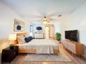 Bright bedroom features a ceiling fan, wooden furniture, and cool-toned wall art at 8127 Tarsier Ave, New Port Richey, FL 34653
