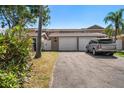 Townhome featuring a two-car garage, private entrance, and manicured landscaping at 829 E Gulf Blvd # 107, Indian Rocks Beach, FL 33785