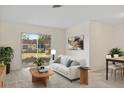 Cozy living room with a sofa, coffee table, area rug and view of the outdoor area through sliding glass doors at 9922 86Th Way, Seminole, FL 33777