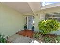 Inviting front entrance featuring a decorative door, potted plants, and a tiled walkway, creating a warm welcome at 12453 138Th N St, Largo, FL 33774