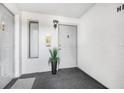 Well lit condo entrance with fresh white walls and new carpet at 1281 Pine Ridge E Cir # H1, Tarpon Springs, FL 34688