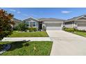 Charming single-story home featuring a manicured lawn and two car garage at 13357 Waterleaf Garden Cir, Riverview, FL 33579