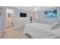 Serene main bedroom featuring light blue walls, a cozy bed, and an ensuite bathroom for added privacy at 1408 Dartmouth Dr, Holiday, FL 34691