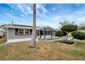 Inviting front porch featuring decorative support columns and landscaping with a palm tree at 1516 Roundtree Rd, Holiday, FL 34690