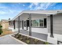 Cozy front porch featuring decorative support columns, modern lighting and landscape at 1516 Roundtree Rd, Holiday, FL 34690