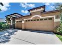 Three car garage with a lush lawn and blue skies at 15724 Ibisridge Dr, Lithia, FL 33547