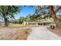 Charming single-story home with a large oak tree, spacious driveway, and unique carport at 1641 Thompson Rd, Lithia, FL 33547