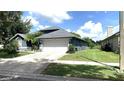 Well-maintained home featuring a spacious driveway, two-car garage, and lush green lawn at 16505 Lake Heather Dr, Tampa, FL 33618