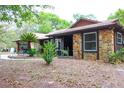 Well-maintained home featuring a harmonious blend of stone and siding exterior with lush landscaping at 16536 Caldwell Ln, Spring Hill, FL 34610