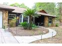 Charming exterior with stone accents, a curved walkway, and manicured landscaping at 16536 Caldwell Ln, Spring Hill, FL 34610