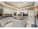 Modern kitchen with white cabinetry, stainless steel appliances, and a granite-topped island at 1750 Arabian Ln, Palm Harbor, FL 34685