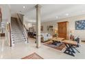 Open concept living area featuring staircase, neutral walls, tile floors, area rugs, and comfortable furniture at 1750 Arabian Ln, Palm Harbor, FL 34685