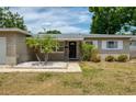 Inviting front entrance with decorative columns, a black front door, and manicured landscaping at 211 80Th N Ave, St Petersburg, FL 33702