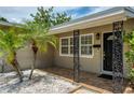 Close-up of the front porch featuring tiled flooring, ornamental pillars, and a black entryway door at 211 80Th N Ave, St Petersburg, FL 33702
