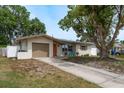Inviting single-story home with a well-maintained lawn, private drive, and quaint outdoor seating at 2153 Pocahontas Dr, Largo, FL 33774