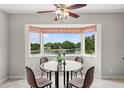 Bright breakfast nook featuring a round glass table, charming window, and relaxing lake view at 2228 Swedish Dr # 22, Clearwater, FL 33763