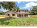 Charming two-story home with a welcoming front porch and red shutters at 2512 Rustic Oaks Dr, Lutz, FL 33559