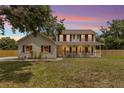 Charming two-story home featuring a spacious front porch and well-maintained lawn at 2512 Rustic Oaks Dr, Lutz, FL 33559