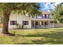 Beautiful two-story home with a large front yard featuring mature trees and a charming swing at 2512 Rustic Oaks Dr, Lutz, FL 33559