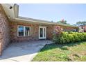 Inviting front entrance featuring brick accents, a glass door, and well-maintained landscaping at 2675 Firestone Dr, Clearwater, FL 33761