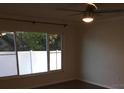 Bedroom features a ceiling fan, a large window, and hardwood floors at 3115 Winchester Dr, Dunedin, FL 34698