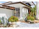 Close up of mid-century modern facade with white tiled walls, brown trim, and decorative plants at 3130 Walnut Ne St, St Petersburg, FL 33704