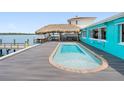 Backyard pool and dock with a tiki bar and lounge area for outdoor entertaining at 326 176Th Avenue Cir, Redington Shores, FL 33708
