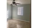 Cozy bedroom with neutral walls, tile floors, a ceiling fan, and natural light from window at 3502 E 33Rd Ave, Tampa, FL 33610