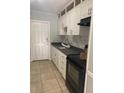 Well-organized kitchen with white cabinets, black appliances and countertops at 3502 E 33Rd Ave, Tampa, FL 33610