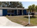 Charming blue home featuring a landscaped front yard, new mailbox, and a welcoming entrance at 3530 Umber Rd, Holiday, FL 34691