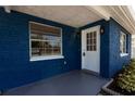 Charming blue home featuring a white door and manicured landscaping near the front entrance at 3530 Umber Rd, Holiday, FL 34691