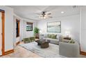 Bright living room features tiled floors, neutral paint, and an elegant ceiling fan and lots of natural light at 39427 Comstock Ln, Zephyrhills, FL 33540