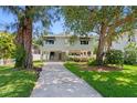A lovely stilt home, a driveway, with mature trees and green grass at 4027 Alabama Ne Ave, St Petersburg, FL 33703