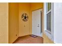 Front porch featuring brick-paved flooring, a decorative wreath, and a storm door at 4949 Marble Springs Cir, Wimauma, FL 33598
