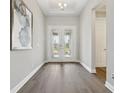 Elegant entryway with decorative glass doors, hardwood flooring, and a tray ceiling, offering a grand welcome at 5477 Wayfarer Ave, Apollo Beach, FL 33572